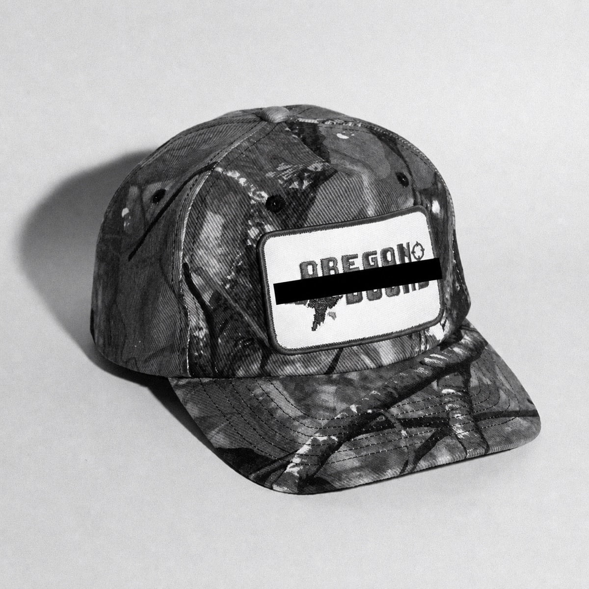 Black-and-white camouflage collegiate parody hat with its embroidery redacted