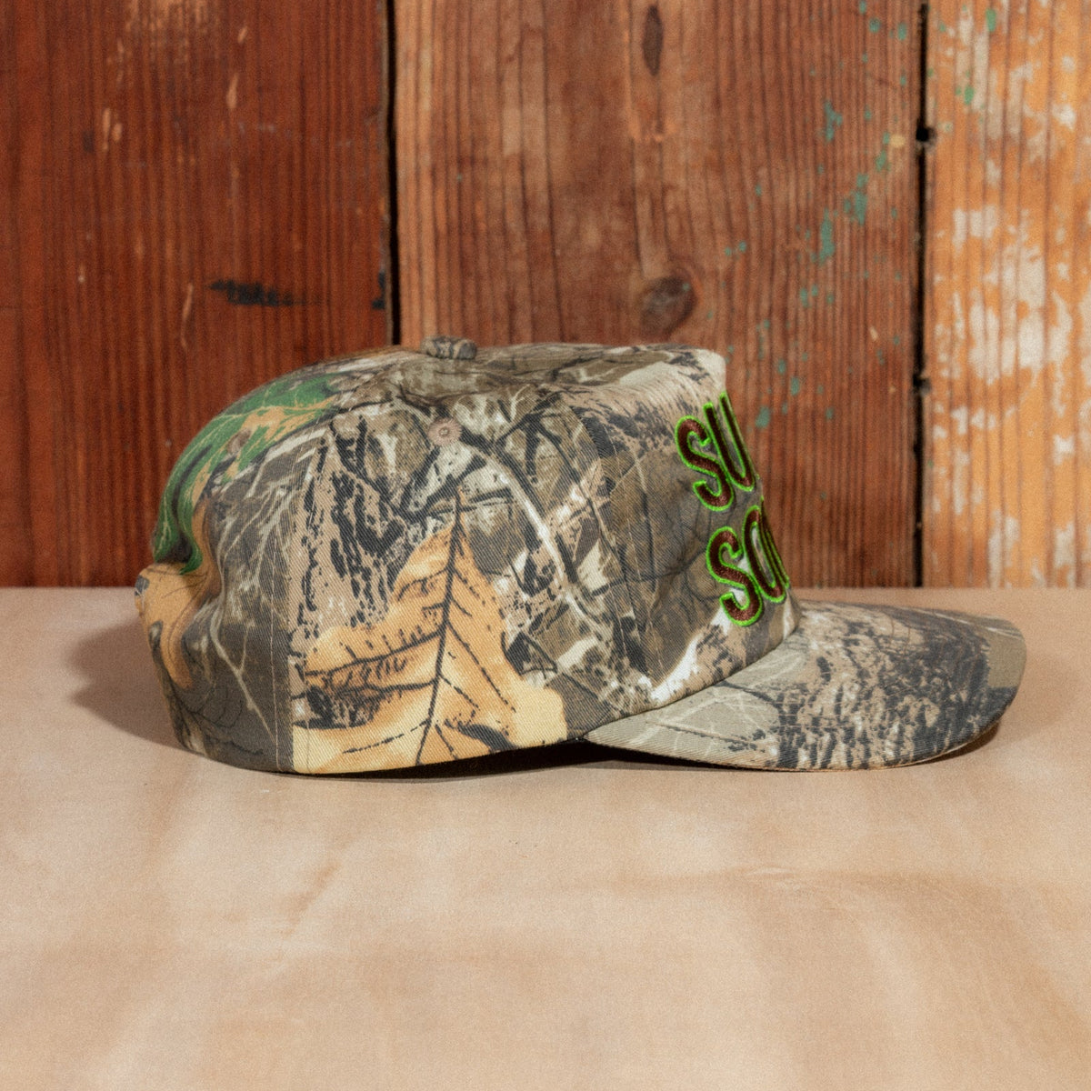 Side profile of the Peak Sonics Hat showing the woodland camo panels and curved brim