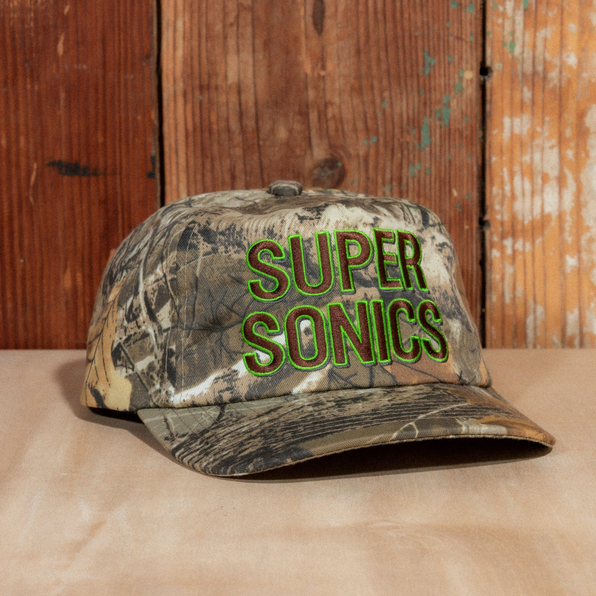 Peak Sonics Hat at a three-quarter angle, showing the curved camo brim and raised Super Sonics lettering