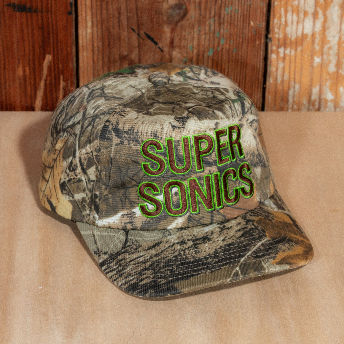 Peak Sonics Hat at a low three-quarter angle, with raised Super Sonics embroidery and camo brim