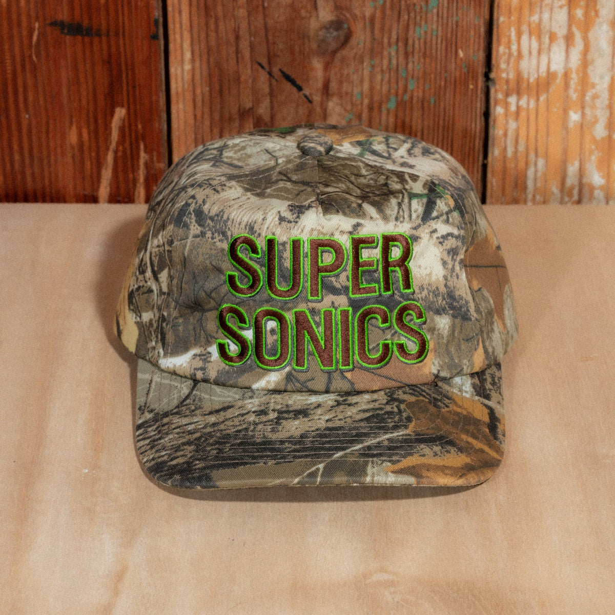 Front close-up of the camo crown and raised brown and green Super Sonics lettering