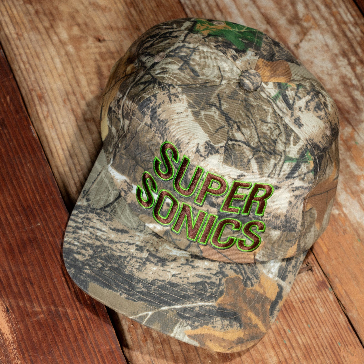 Peak Sonics Hat lying on weathered wooden planks, seen from above