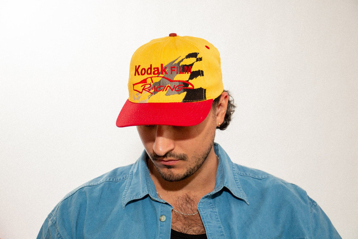 Man wearing the yellow Kodak Film Racing Team snapback