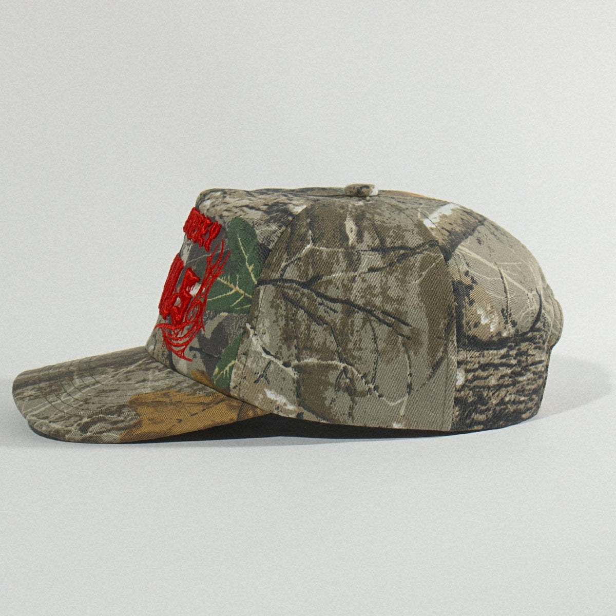 Side profile of the camo snapback showing the high crown and pre-curved brim