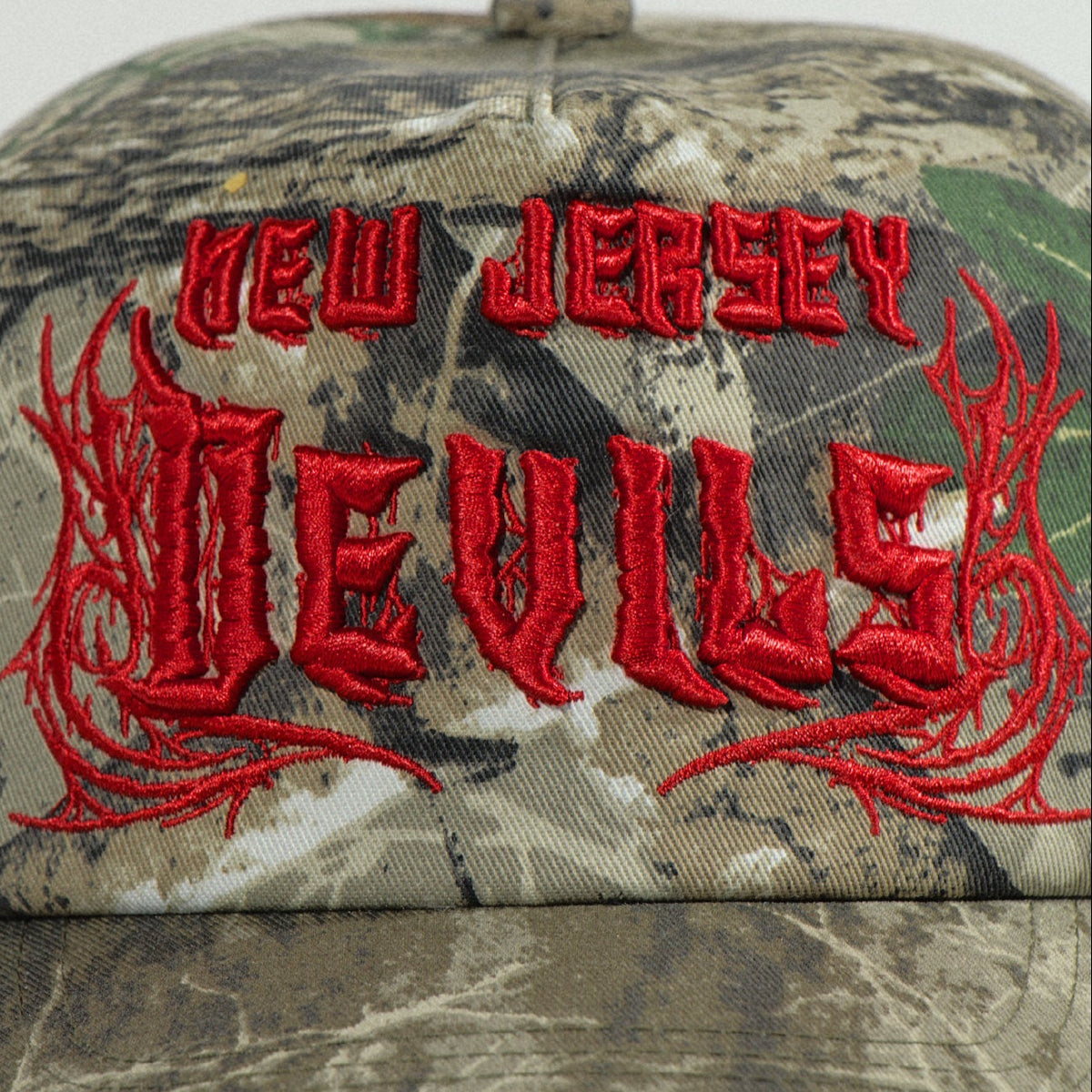 Close-up of the raised red New Jersey Devils embroidery in a jagged metal-band script