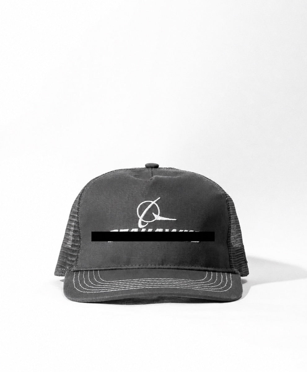 Black-and-white aerospace parody hat with its embroidery redacted